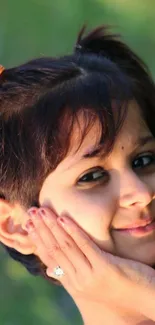 Smiling child portrait against green nature background.