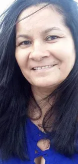 Smiling woman in blue dress, close-up.