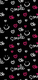 Black wallpaper with pink and white smiley faces and hearts.