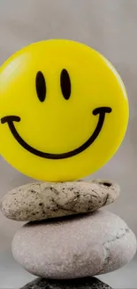 Cheerful yellow smiley face on balanced stones. Dominantly yellow.