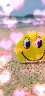 Smiley face on sandy beach with ocean in background.