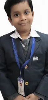 Smiling child wearing school uniform with white background.