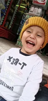 Joyful child in a yellow beanie, smiling brightly.