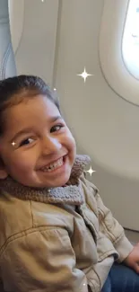 Smiling child sitting by airplane window seat.