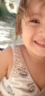 Portrait of a smiling child outdoors under sunlight.