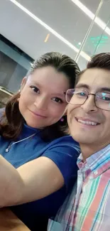 Smiling couple taking a selfie in a cafe.