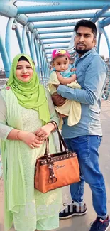 Smiling family poses on an urban bridge.