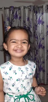 Smiling girl in a white floral dress.