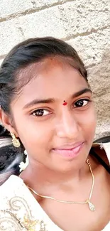 Young girl in traditional attire with a bright smile and elegant jewelry.