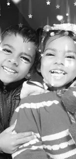 Two smiling children in a black and white photo wallpaper.