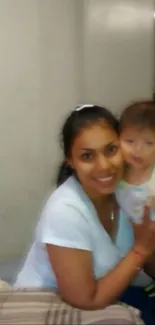 Smiling woman holding a baby in her arms.