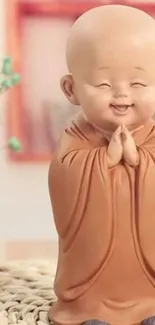 Smiling monk statue with hands clasped in prayer.