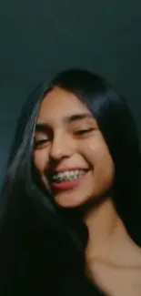 Young woman with long dark hair smiling brightly.