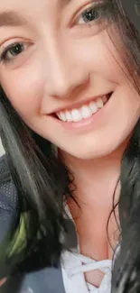 Close-up of a smiling woman with dark hair.