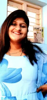 Smiling woman in blue dress indoors, looking happy and positive.