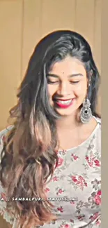 Smiling woman in floral dress with long hair and earrings.