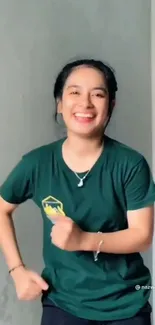 Smiling woman in green shirt posing indoors.