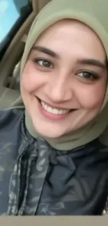 Smiling woman in a hijab inside car.