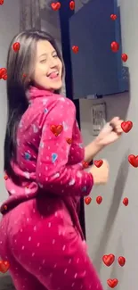 Smiling woman in red pajamas with hearts.