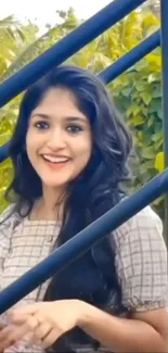 Smiling woman on stairs with background greenery.