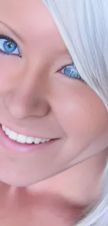 Portrait of a smiling woman with blue eyes and platinum hair.