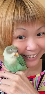 Smiling woman holding a green parrot in vibrant setting.