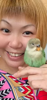 Woman smiling while holding a bird.