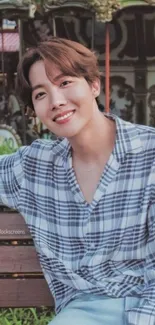 Cheerful young man sitting on a park bench with a smile.