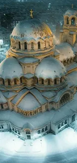 Snow-covered cathedral illuminated at night, creating a serene winter scene.