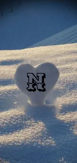 Heart-shaped snow sculpture in a winter landscape with soft slopes.