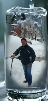 Snow scene reflected inside a tall glass of water.