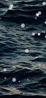 Snowflakes gently falling over dark ocean waves in a serene mobile wallpaper.