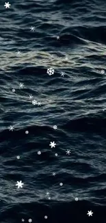 Snowflakes falling over dark ocean waves creating a calming winter wallpaper.