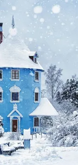Blue house in snowy winter landscape with trees.