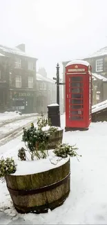 A red phone booth on a snowy British street.