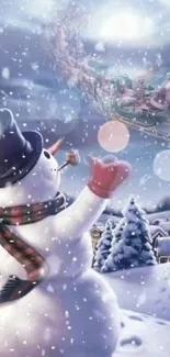 Snowman waving at Santa's sleigh in a snowy landscape.