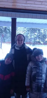 Family standing together in snowy outdoor setting with warm winter clothing.