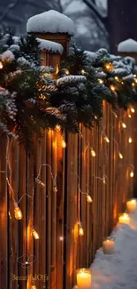 Snowy fence with warm festive lights glowing amidst winter night.