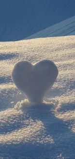 Heart-shaped snow sculpture in glowing sunrise on winter landscape.