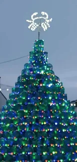 Snowy holiday village with Christmas tree and lights.