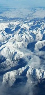 Aerial view of snow-covered mountains and blue sky.