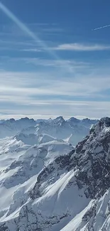 Snowy mountain range with blue sky and clouds.