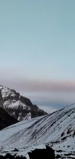 Snowy mountain landscape with rugged peaks and a serene sky.