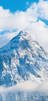 Snowy mountain peak under a bright blue sky with white clouds.