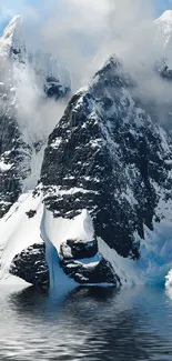 Snowy mountain peaks with serene reflections on water.