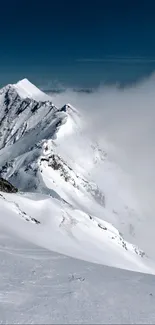 Snow-covered mountain peak with misty clouds.