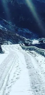 Snow-covered mountain road under clear sky.