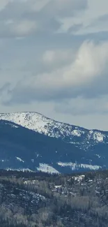 Serene snowy mountain under a cloudy blue sky.