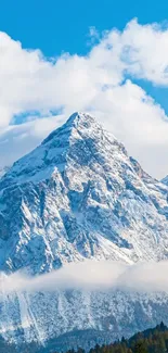 Snowy mountain peak under bright blue sky with white clouds.