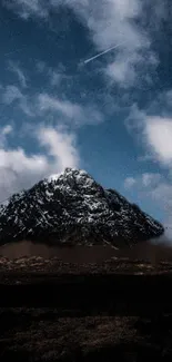 Snowy mountain beneath a vibrant blue sky with clouds.